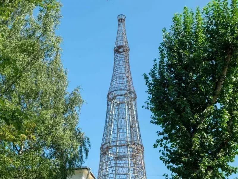 Шуховская башня на Шаболовке между кронами деревьев летним днём